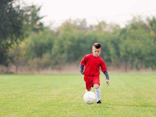 Young soccer player in action with ball