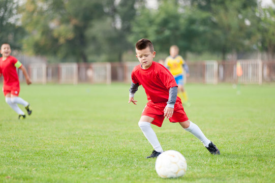 Little soccer player in action with ball