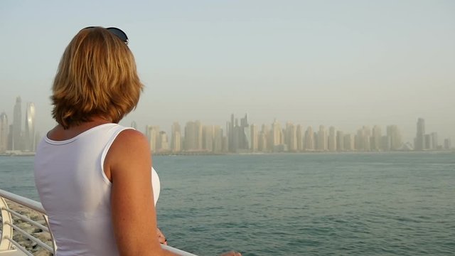 Dubai quay in the daytime with a young woman.