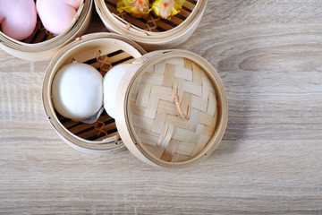 Obraz na płótnie Canvas Streamed chinese buns, Dim Sum in round bamboo crate