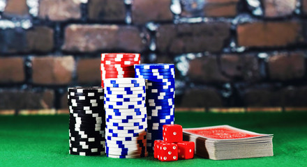 Casino chips and cards on green playing table