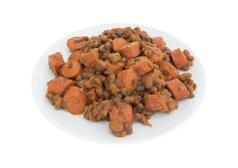 Beans and hot dogs on a plate isolated on a white background.