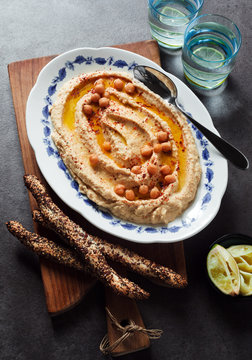 Healthy Homemade Creamy Hummus with Olive Oil  and breadsticks w