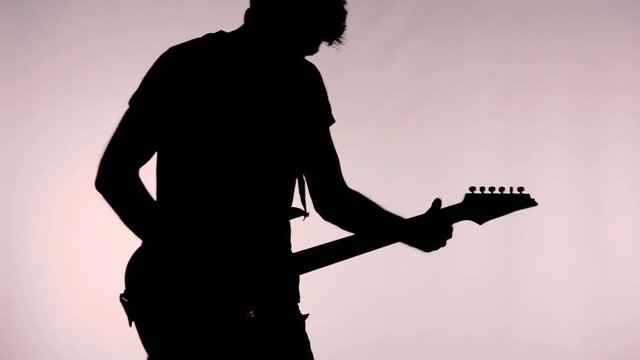 Silhouette of man playing guitar