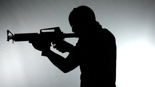Silhouette of man with assault rifle