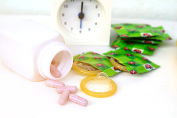 Obraz na płótnie Canvas Condom and medicine concept eat medicine for power strength clock show 6 oclock. Selective focus and soft flare sunlight.