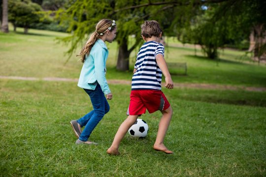 Boy and girl playing football