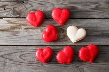Fototapeta premium Red macaroons desserts on wooden background. dessert for breakfast on Valentine's Day