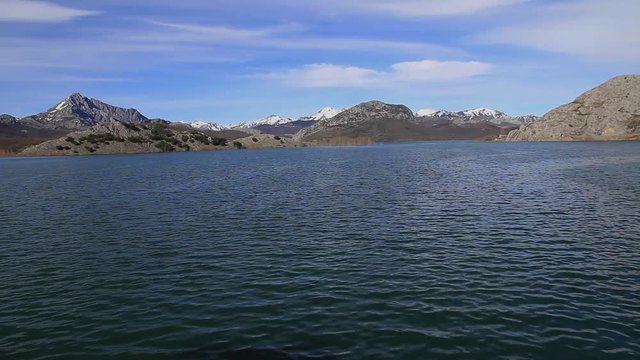 Paisaje de monta&ntilde;as con restos de nieve y embalse o pantano
