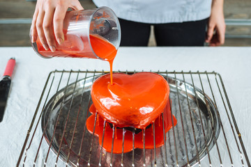 The process of pouring glaze on the cake in the form of heart