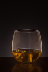 glass of whiskey backlit on a dark background