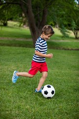 Boy playing football in park