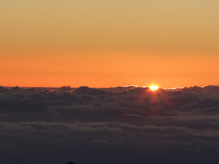 Fototapeta na wymiar Sun peeking over clouds at sunrise