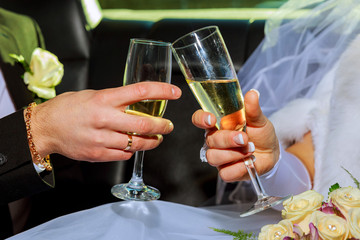 Womans and mans wedding hands with glasses.