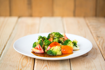 tomatoes and broccoli stir-fry. in plate on table