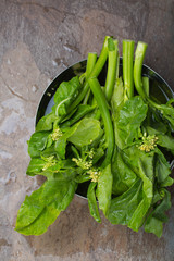 Gai Lan - Asian leafy vegetable on a brown stone background