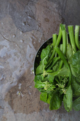 Gai Lan - Asian leafy vegetable on a brown stone background