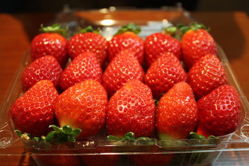 Fresh red strawberries in transparent a box close up