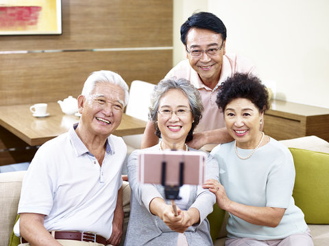 two senior asian couples taking a selfie