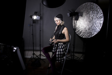 Creative female professional photographer in a strobe lighting studio.  She portrays an independent self employed freelance entrepreneur.  The image depicts the photography arts.
