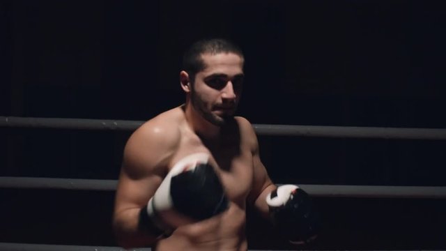 Muscular MMA athlete entering ring and warming up before fight