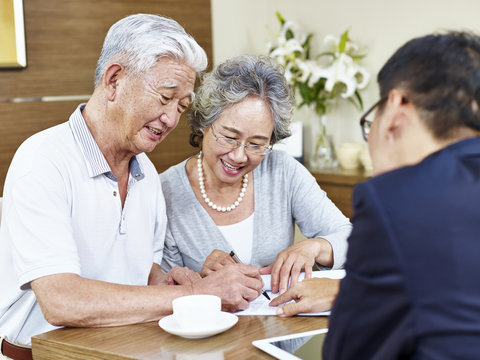 senior asian couple signing a contract