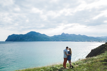 Couple walking outdoors by the sea and enjoying beautiful mountain view