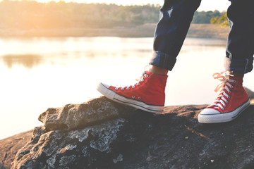 Feet red sneaker a girl in nature and relax time on holiday. selective and soft focus color of...