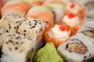 Assorted sushi set served in white box against white background
