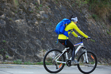 Fototapeta na wymiar one young woman cyclist riding mountain bike on forest trail