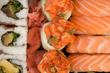 Assorted sushi set served in white box against white background