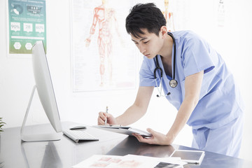 The doctor is watching the chart in the examination room