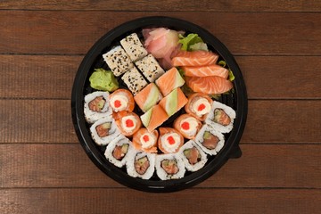 Fototapeta na wymiar Set of assorted sushi kept in a black round box