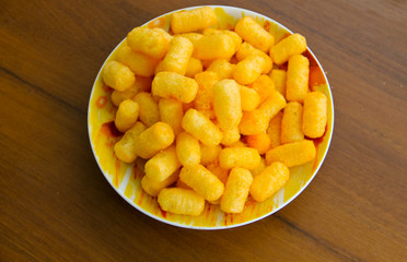 Corn sticks in bowl on wooden table