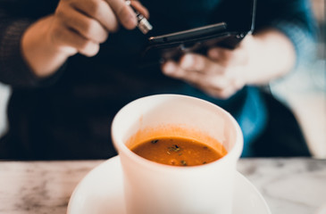 man holding smartphone during lunch in coffee shop