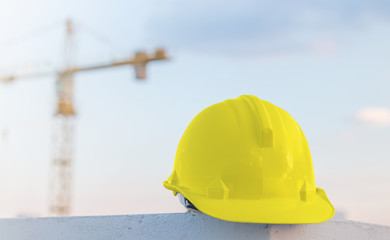 The white safety helmet at construction site with crane backgrou