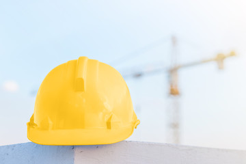 The white safety helmet at construction site with crane backgrou
