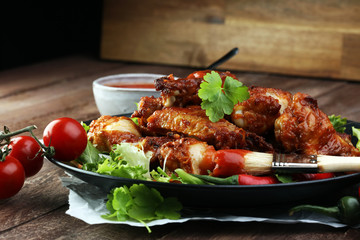 barbecue chicken wings close up on wooden tray with red spice sa