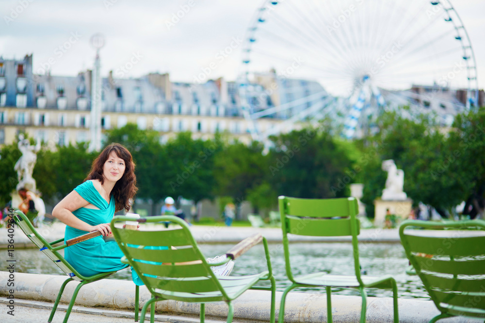 Wall mural Beautiful young woman relaxing in Parisian Tuileries park