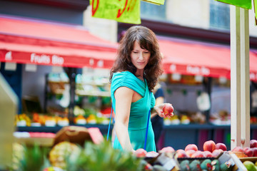 French woman choosing fruits on market