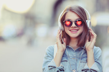 Young beautiful woman wearing sunglasses with hearts on blurred background