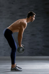 Obraz premium Sporty man doing exercises with barbell indoors