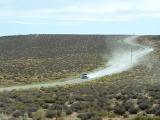 アメリカの荒野を土煙をあげて走る車