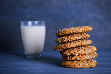 Delicious cereal cookies with glass of milk on color background