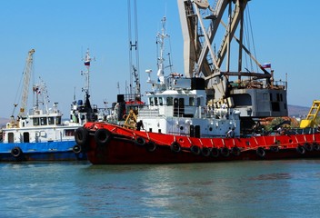 Cargo ship sailing in sea near port, red