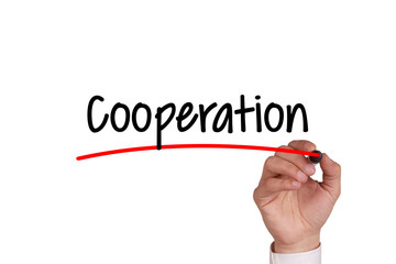 Human hand writing COOPERATION on whiteboard