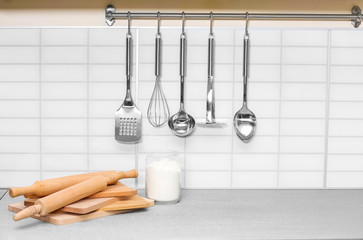 Set of metal kitchen utensils hanging on wall