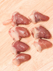 Fresh chicken hearts on a wooden background