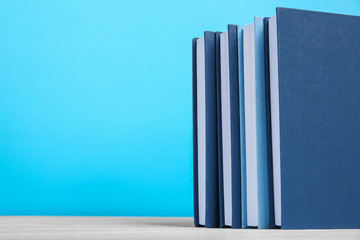 Books on wooden table and blue background