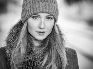 Black and white portrait of young woman at sunny winter day.